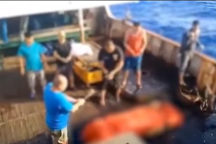 Sebuah tangkapan layar dari video yang dipublikasikan media Korea Selatan MBC memperlihatkan, eorang awak kapal tengah menggoyang sesuatu seperti dupa di depan kotak yang sudah dibungkus kain berwarna oranye. Disebutkan bahwa kotak tersebut merupakan jenazah ABK asal Indonesia yang dibuang ke tengah laut oleh kapal asal China.(MBC/Screengrab from YouTube)