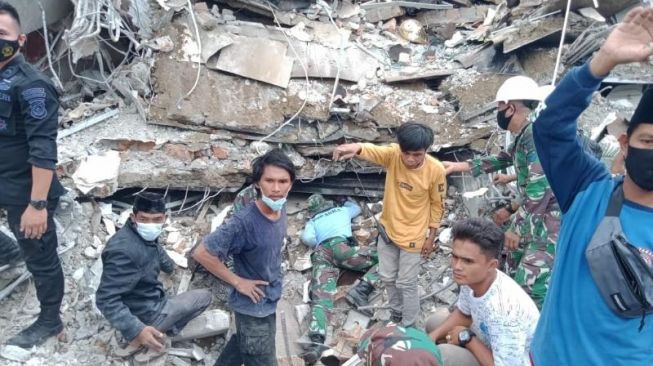 TNI AL bersama warga melakukan proses evakuasi korban gempa di Kantor Gubernur Sulbar. (Suara).